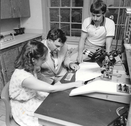 <B>Lead Bonder </B><BR>Taken in oriiginal AMI lab on Morris Street. Pictured with Doug are Linda Weaver and Greg Chauvin -- graduate students at the time